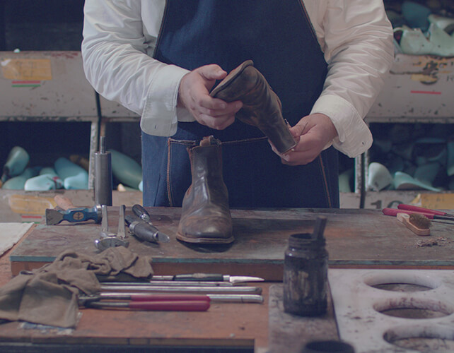 Boots being repaired by the hands that made them Boots being repaired by the hands that made them