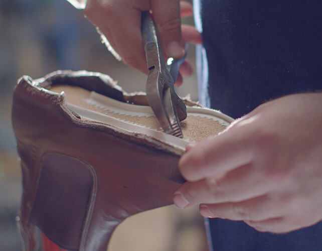 Boots being repaired by the hands that made them Boots being repaired by the hands that made them